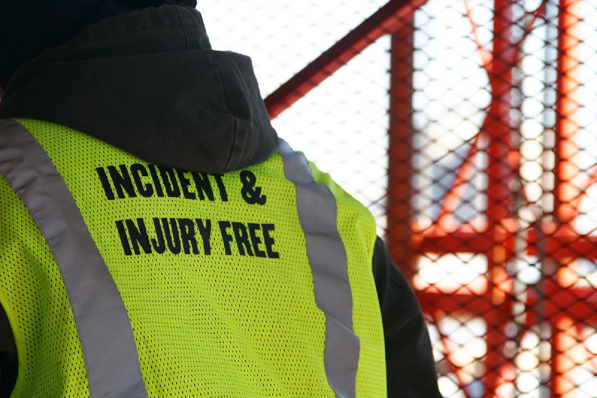 Man wearing high-vis jacket with the words Incident and Injury free on the back